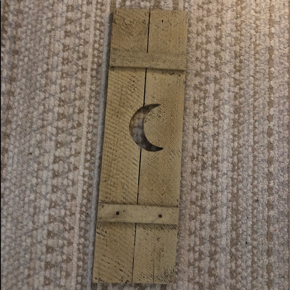 White wash panel with half moon cut out with two hooks at the bottom.